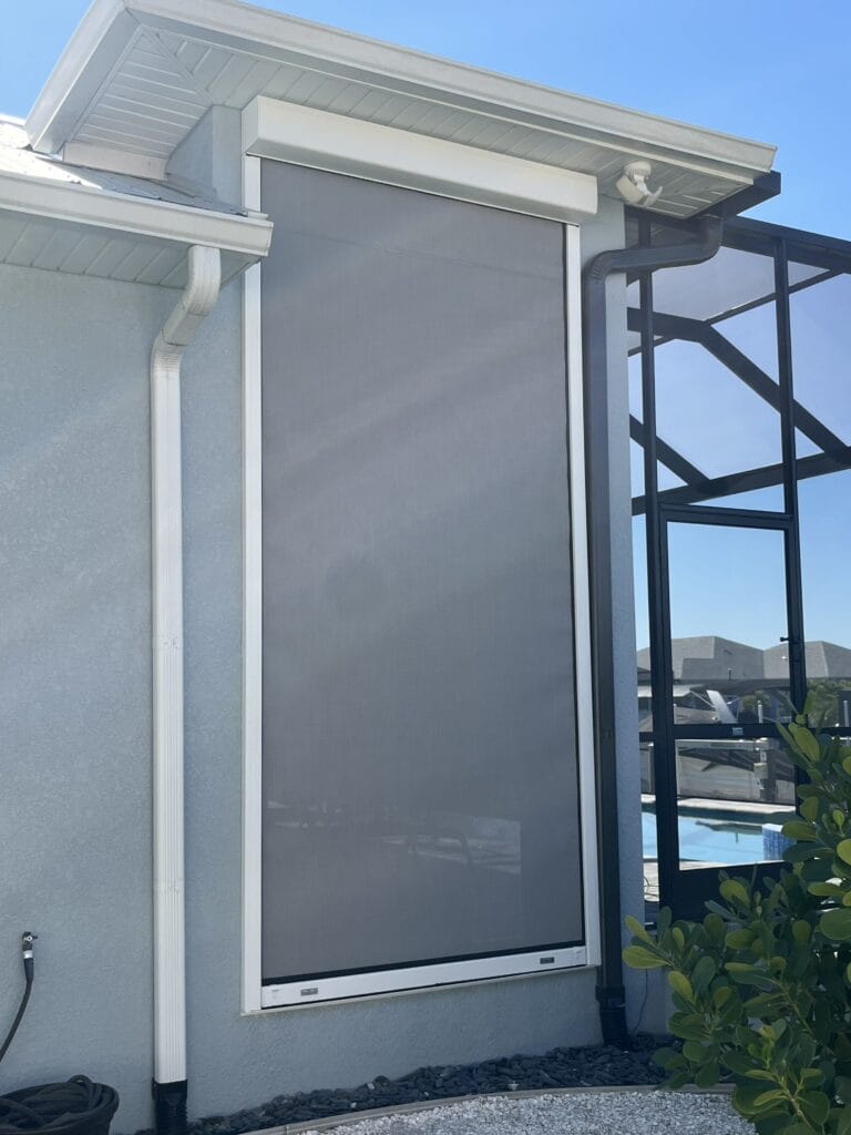 Retractable hurricane screen protecting the side of a pool enclosure