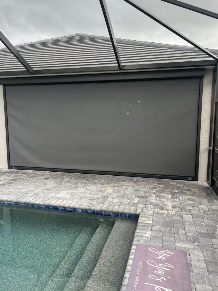 Hurricane screen protecting a covered patio beside a swimming pool