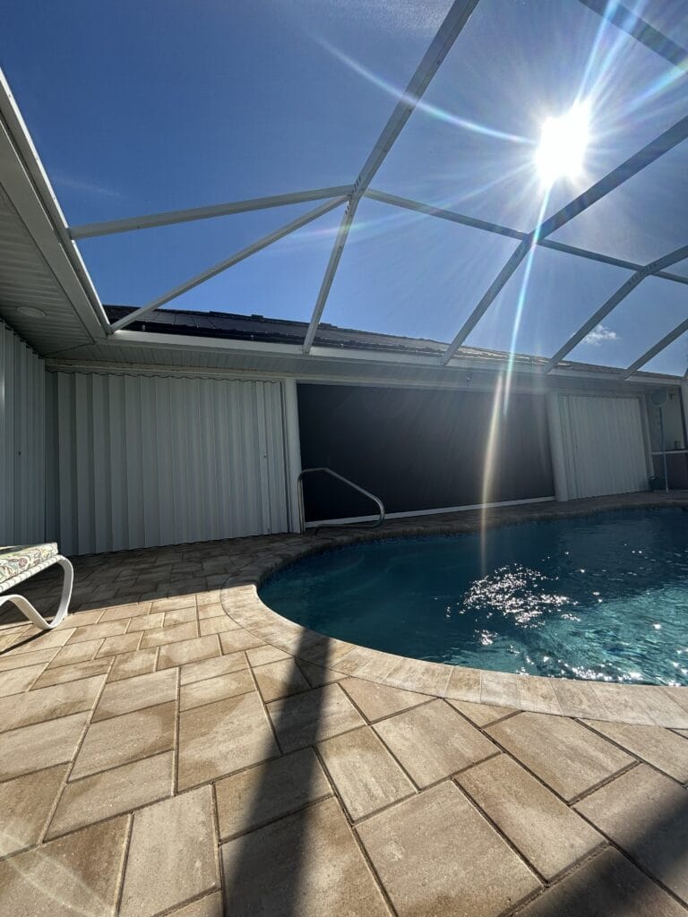 Retractable hurricane screen installed inside a screened pool enclosure